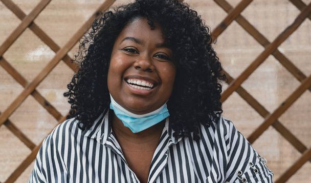 Ritratto di donna africana sorridente durante l'epidemia di virus della corona - Foto, immagini