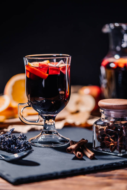 Still life - mulled wine, hot red wine with spices in glass among fruits. Scented cozy Christmas celebration, fragrant punch concept. - Foto, imagen