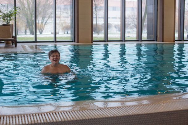 happy man in  pool with panoramic windows - Foto, Imagem