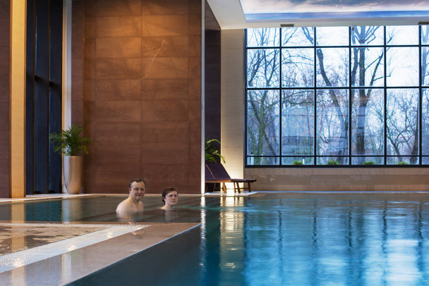 two men in  beautiful pool with panoramic windows - 写真・画像
