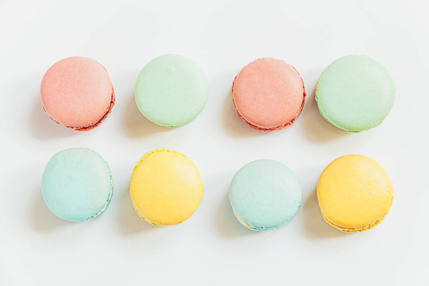 Sweet almond colorful pastel pink blue yellow green macaron or macaroon dessert cake isolated on white background. French sweet cookie. Minimal food bakery concept. Flat lay top view copy space - Foto, Imagen