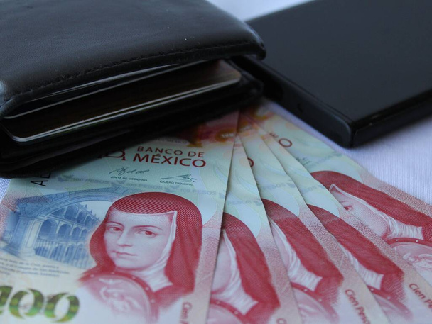 dinheiro mexicano, carteira de couro preto e canto do smartphone na mesa - Foto, Imagem
