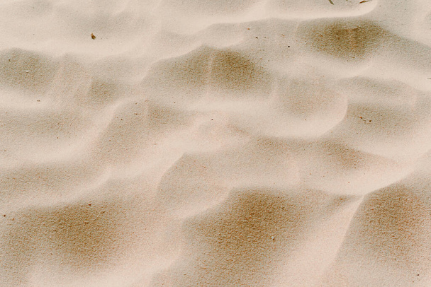 sand dunes close-up view from above. Background beige photo. sand waves. texture of sand on the beach - Photo, Image