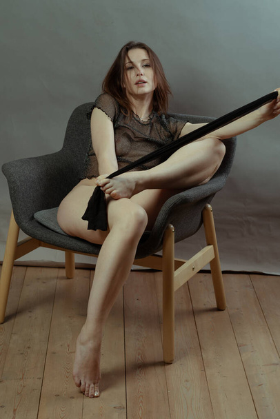 joven hermosa mujer pose en lencería negra en el estudio, sentado en una silla - Foto, imagen