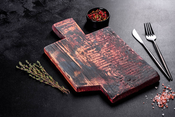 Corte de tábua de madeira, bem como legumes e uma mesa escura especial. Preparação para a produção alimentar - Foto, Imagem