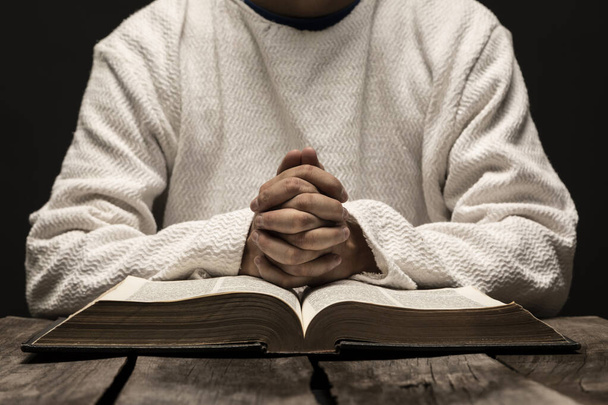 Jesus Christ Praying and reading the Holy Bible in the dark black night - Fotó, kép