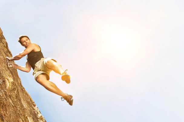 Photo of Climber Jumping off Cliff with yellow lens flare - Фото, зображення