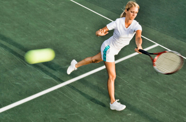 Portrait of young attractive tennis woman player hitting the ball - Φωτογραφία, εικόνα
