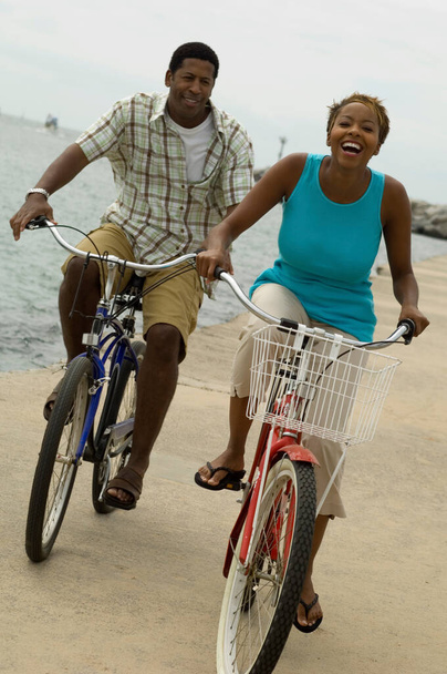Photo of african american couple riding bicycle on seashore - Foto, Bild