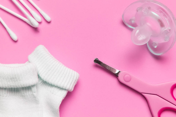 Baby-blaue Schere für Hygiene, Baby-Gumminippel beruhigender, Socken auf rosa Hintergrund Ansicht flache Lagekopierraum. Baby-Nagelschere aus Metall und Kunststoff. Manikürschere. Babypflegekonzept - Foto, Bild