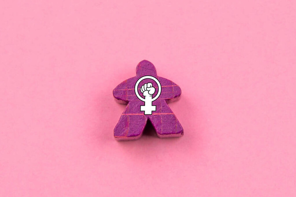 Paarse houten pop met het feministische symbool in het midden. Feminisme en empowerment van vrouwen. 8 maart Internationale Vrouwendag - Foto, afbeelding