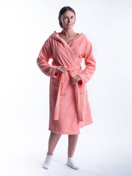 woman in a Bathrobe on an isolated white background with a smile on her face. Shot in the Studio in full growth. - Foto, Imagen
