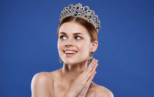 Charming princess with a crown on her head and earrings make-up model - Foto, imagen