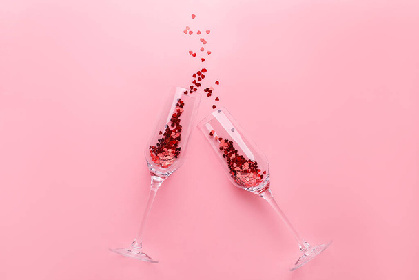 Clinking champagne glasses with splash of red confetti  - Fotoğraf, Görsel