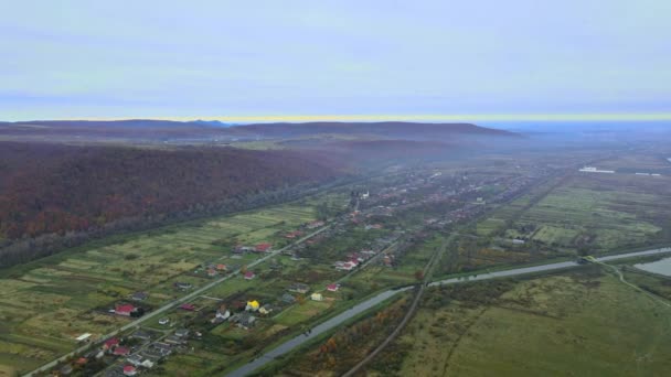 Prachtig uitzicht vanuit de hoogte van het landelijke dorp met huizen en straten, omgeploegde velden, weilanden - Video