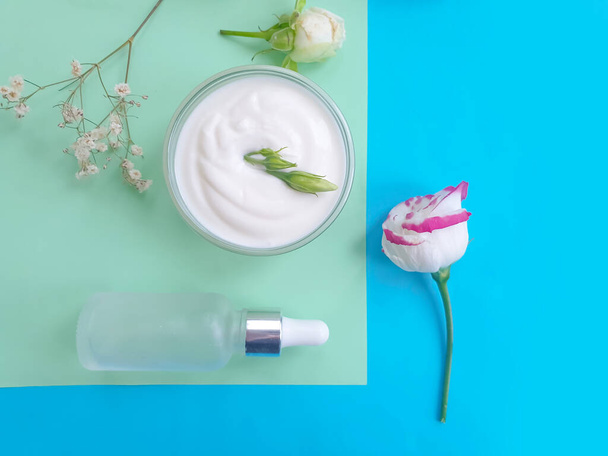 Kosmetikcreme, Rosenblüte auf farbigem Hintergrund - Foto, Bild