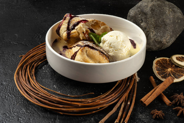 Strudel met ijs. Klassiek zoet dessert met bessensaus en vanille ijsschep. - Foto, afbeelding