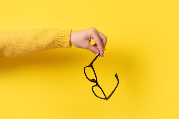 glasses in hand on yellow background - Photo, Image