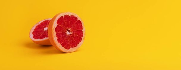 Ganze und geschnittene Grapefruit auf gelbem Hintergrund, Panoramabild - Foto, Bild
