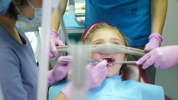 Dentysta zdejmuje maskę ze śmiechu małej dziewczynki kończącej leczenie zębów. Szczęśliwe i zadowolone dziecko uśmiechnięte. Nowoczesny gabinet dentystyczny. przy użyciu środków uspokajających wziewnych. Nie bój się dentysty. 4 tys. wideo - Materiał filmowy, wideo