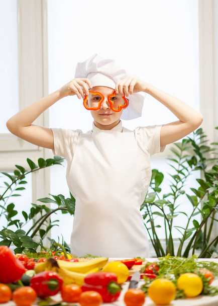 Pequeño niño lindo vestido como un cocinero en la cocina - Foto, imagen