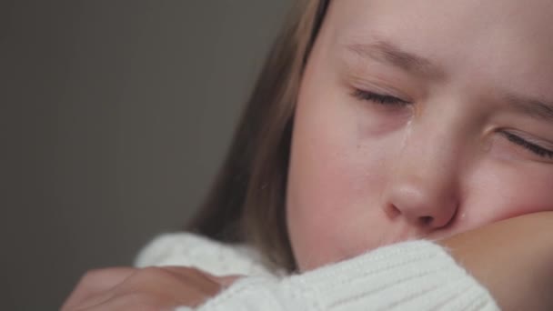 Teini-ikäinen lapsi itkee ja kyyneleet valuvat poskia pitkin. Tyttö on järkyttynyt kehon hormonaalisten muutosten vuoksi. Lasten hermostuneisuus ikäisensä ja vanhempiensa ongelmista. Elämäntyylin sielu itkee. Pelko ja - Materiaali, video