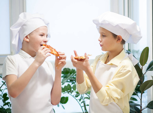 Zwei niedliche europäische Jungen kneten als Koch Mehl, Milch und Eier, Kinder spielen in der Küche - Foto, Bild