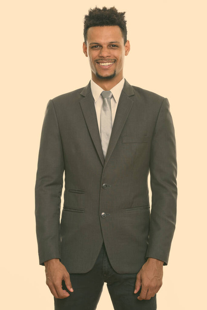 Studio shot of young happy African businessman smiling while standing - Fotó, kép