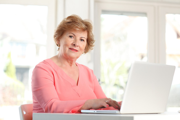 Senior woman working on laptop - Foto, afbeelding