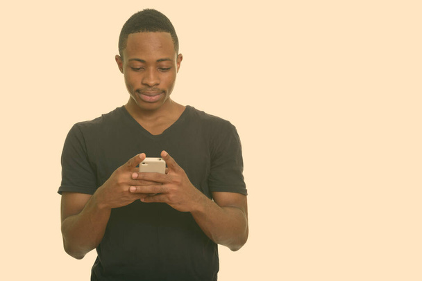 Joven hombre africano guapo usando el teléfono móvil - Foto, imagen