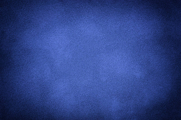 Navy blue matte background of suede fabric with vignette, closeup. Velvet texture of seamless indigo textile with gradient, macro. Structure of sapphire felt canvas backdrop. - Foto, afbeelding