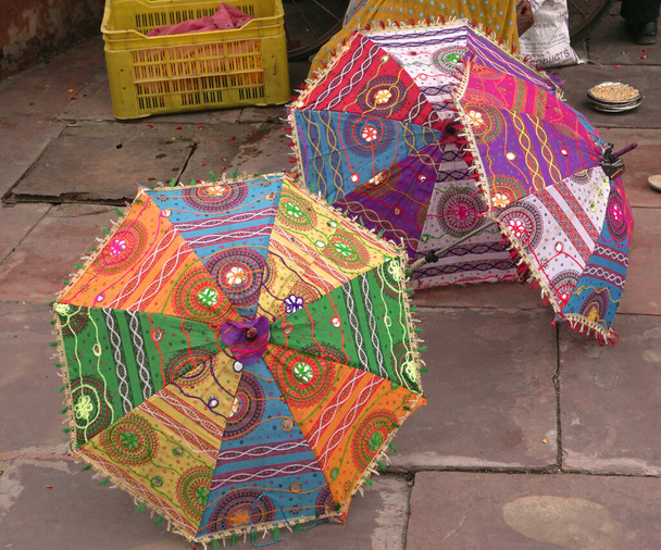 Closeup of colorful umbrellas on road at daytime  - Фото, изображение