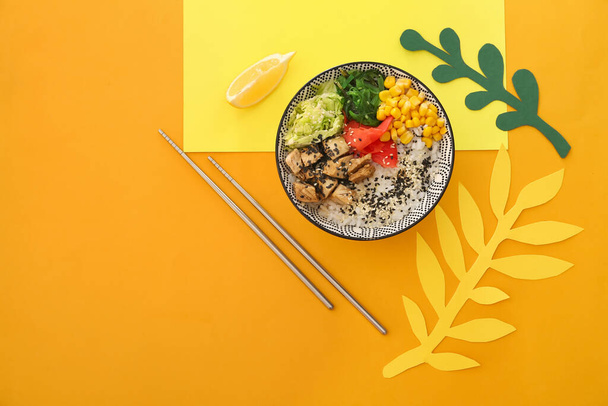 Bowl with tasty rice, chicken and vegetables on color background - Photo, Image