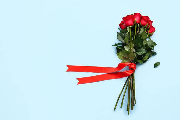 Μπουκέτο με όμορφα κόκκινα τριαντάφυλλα στο φόντο χρώμα - Φωτογραφία, εικόνα
