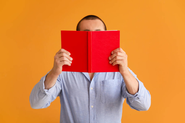 Man with book on color background - Foto, imagen