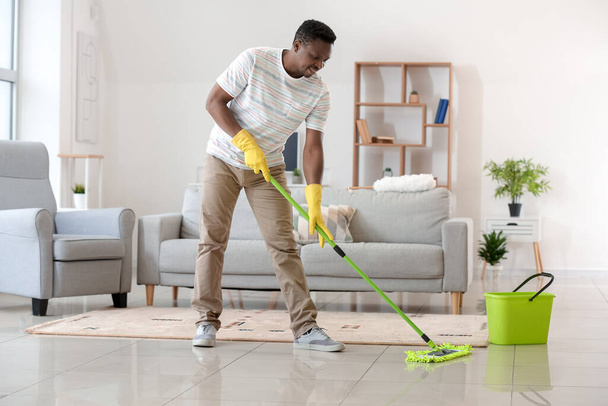 afro-americano uomo pulizia il suo appartamento - Foto, immagini