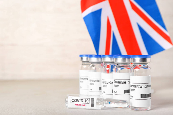 Szczepionka przeciwko COVID-19 i fladze Wielkiej Brytanii na stole - Zdjęcie, obraz
