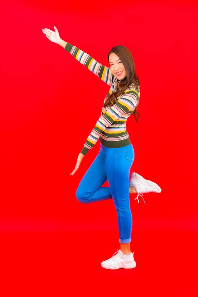 Portrait beautiful young asian woman smile with action on red isolated background - Foto, Imagen
