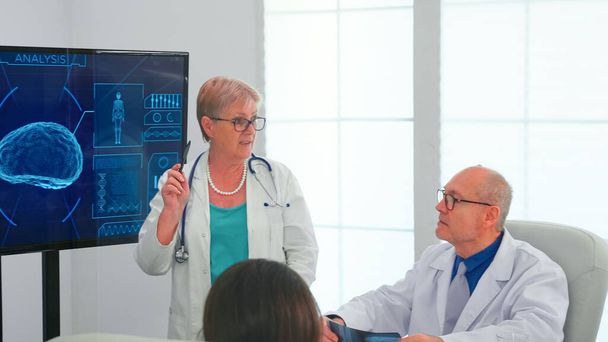 Neurologe liest Hirnströme auf Monitor ab - Foto, Bild