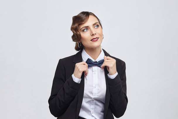 attractive woman with a retro hairstyle poses in a man's suit. photo shoot in the studio on a white background - Fotoğraf, Görsel