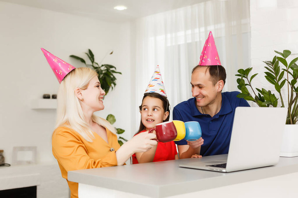 Happy family celebrating birthday via internet in quarantine time, self-isolation and family values, online birthday party - Photo, Image