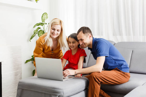 οικογένεια που εργάζονται και σπουδάζουν σε φορητό υπολογιστή στο διαδίκτυο - Φωτογραφία, εικόνα