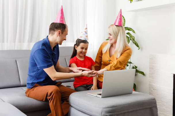 Ευτυχισμένη οικογένεια γιορτάζει τα γενέθλιά της μέσω του Διαδικτύου σε καραντίνα, αυτο-απομόνωση και οικογενειακές αξίες, online πάρτι γενεθλίων - Φωτογραφία, εικόνα