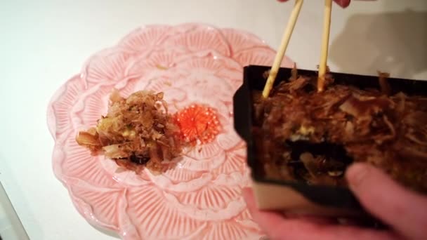 commander des plats à emporter. sur une assiette mettre des rouleaux japonais avec des copeaux de thon croustillants - Séquence, vidéo