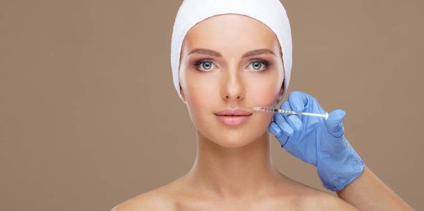 Doctor injecting in a beautiful face of a young woman. Plastic surgery concept. - Foto, Imagem