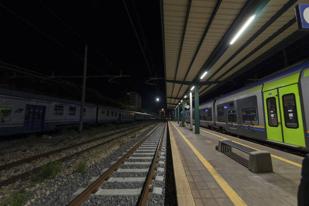 Rautatieasema, jolla juna odottaa raiteilla yöllä - Valokuva, kuva
