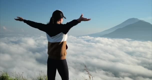 Mädchen, das die Hände hebt, freut sich am frühen Morgen über den neuen Tag auf dem Gipfel des Vulkans - Filmmaterial, Video