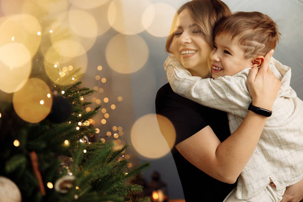 young beautiful mother with her son at home on Christmas - Photo, image