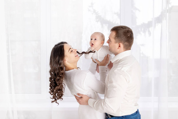 familia feliz madre y padre tienen un bebé recién nacido en casa, el concepto de familia amorosa feliz, estilo de vida - Foto, imagen