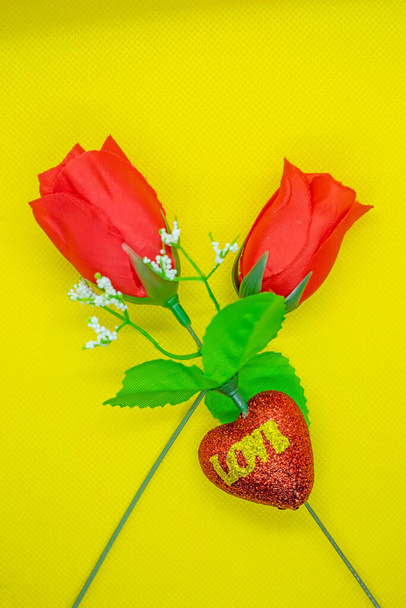 Το φόντο του Αγίου Βαλεντίνου. Κόκκινο τριαντάφυλλο σε κίτρινο φόντο. Για κάρτα και γάμο. - Φωτογραφία, εικόνα